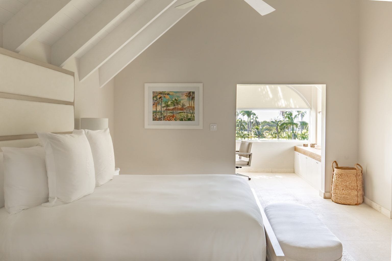 Une chambre avec un grand lit, un tableau accroché au mur et une vue sur l’extérieur.