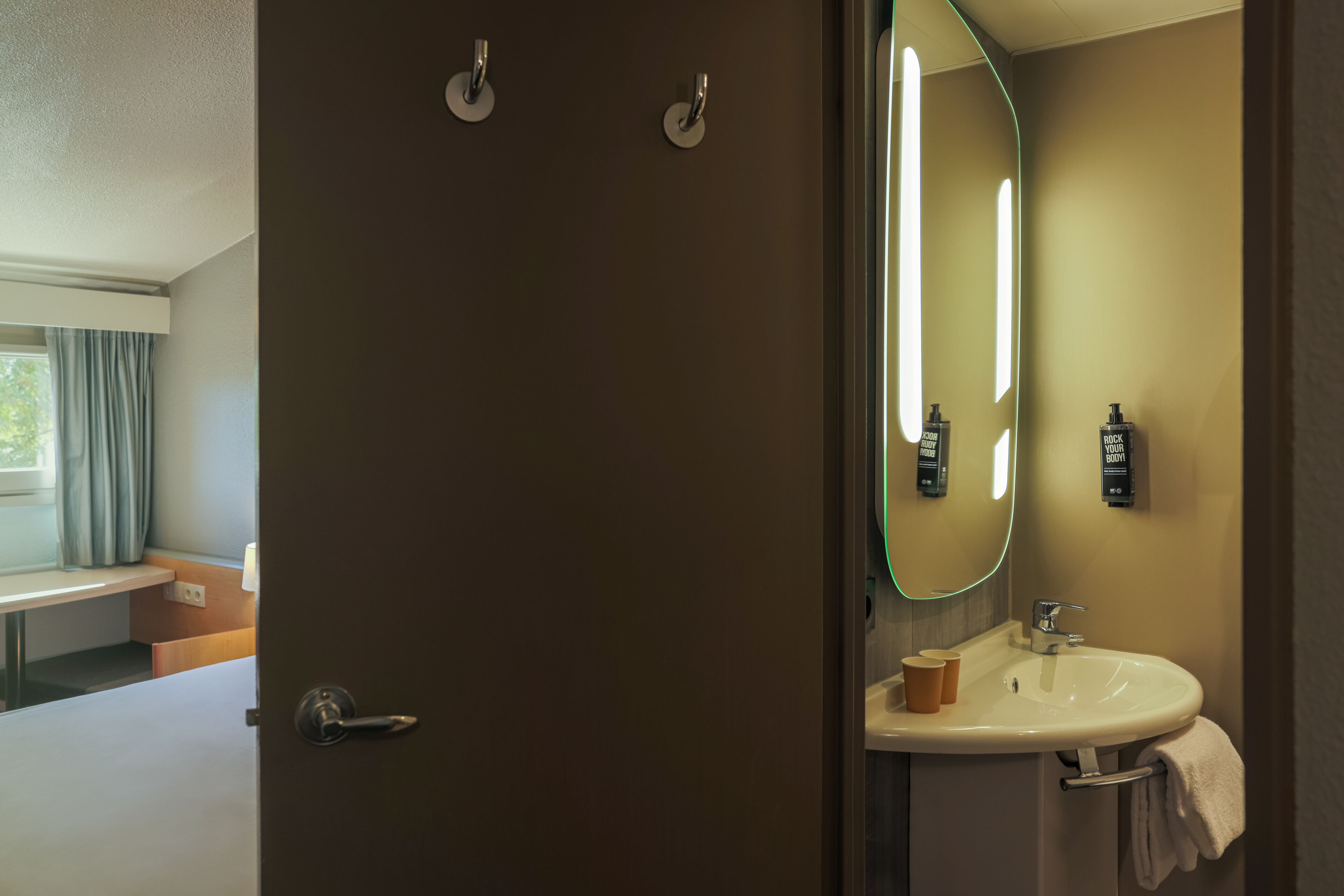 Une salle de bain équipée d’un lavabo, d’un miroir et d’articles de toilette.