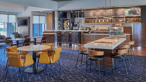 A modern bar area with a bar counter, seating, and a menu board.