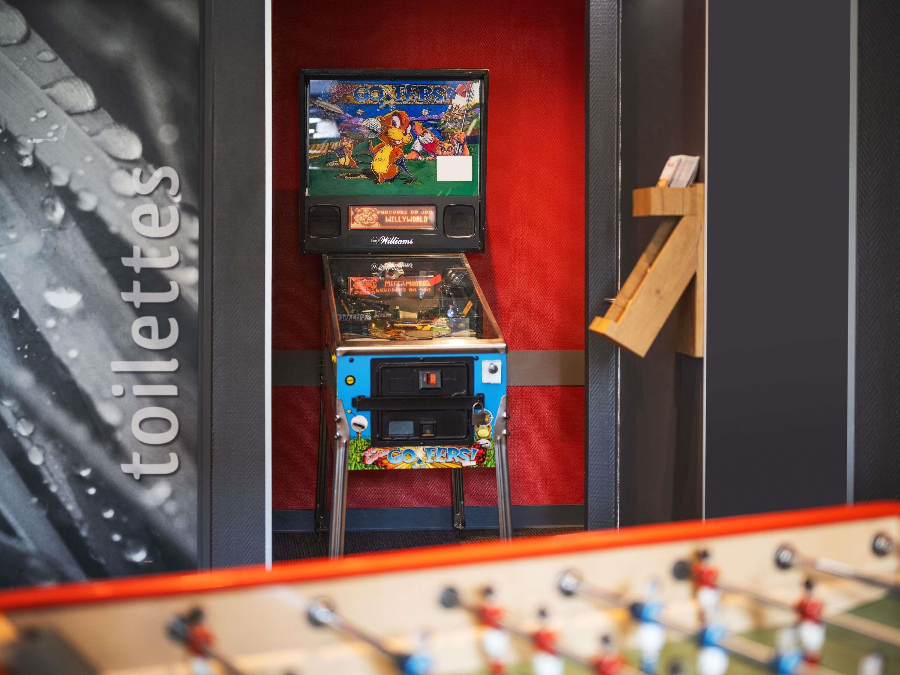 A room with a foosball table, a Nintendo 64 console, and a television displaying a game.
