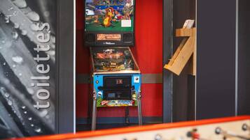 A room with a foosball table, a Nintendo 64 console, and a television displaying a game.