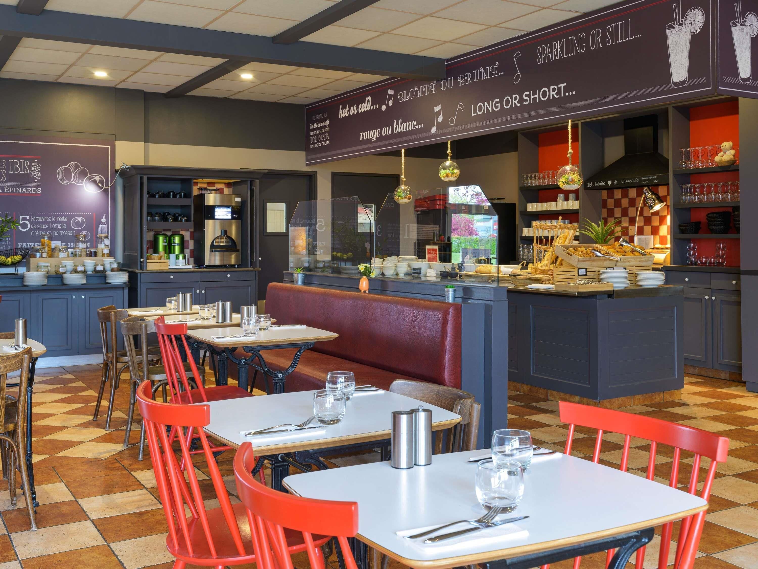A restaurant interior with tables, chairs, a counter, and a chalkboard menu.