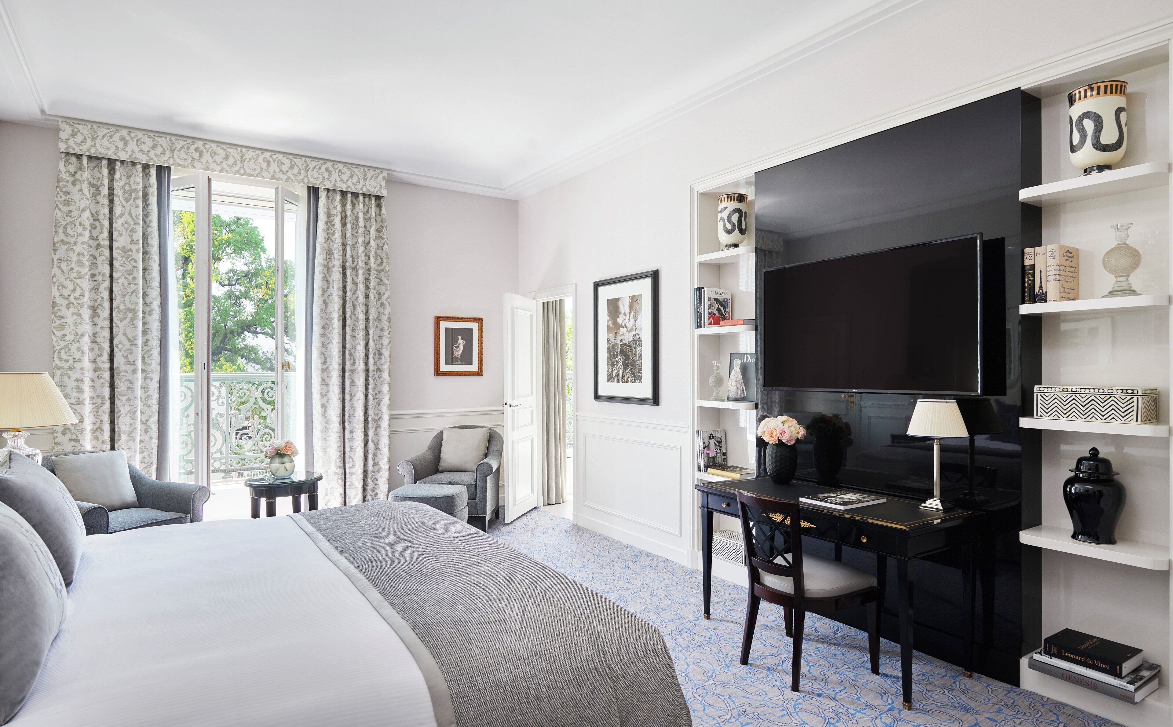 Une chambre d’hôtel comprenant un lit, un bureau avec une chaise, une télévision et une bibliothèque.