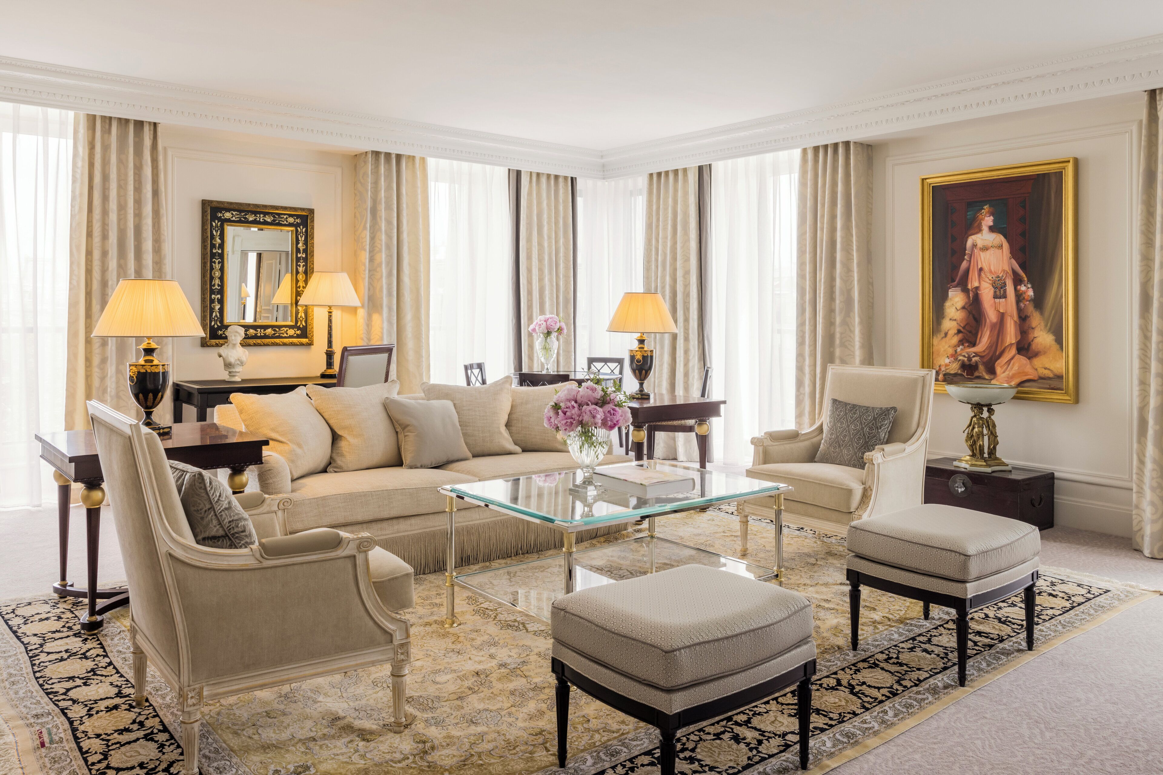 A spacious living room with a sofa set, a glass coffee table, and two armchairs.