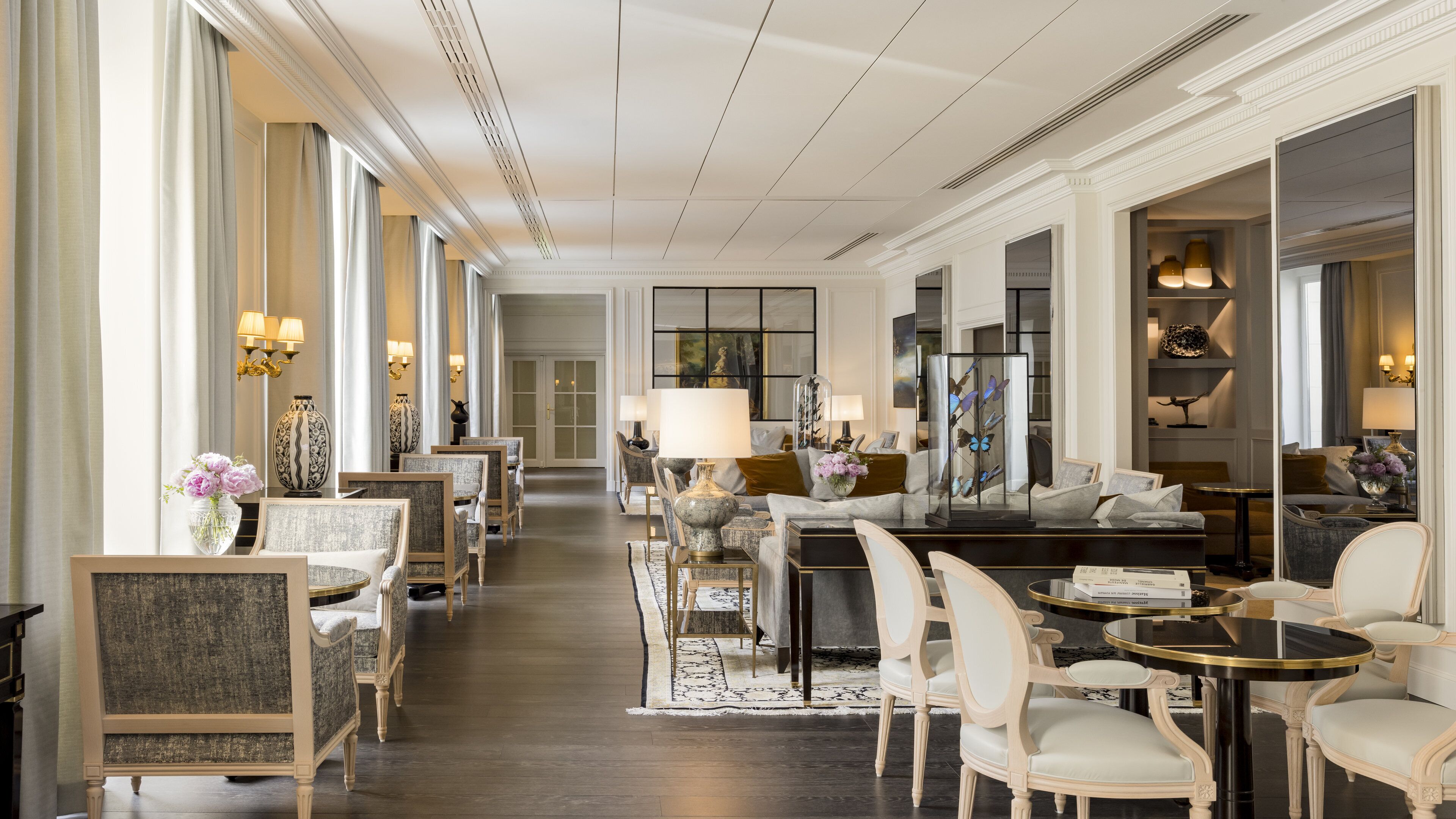 Un hall d’hôtel spacieux, doté d’un long comptoir d’accueil, de coins salons confortables et d’une grande fenêtre laissant entrer la lumière naturelle.