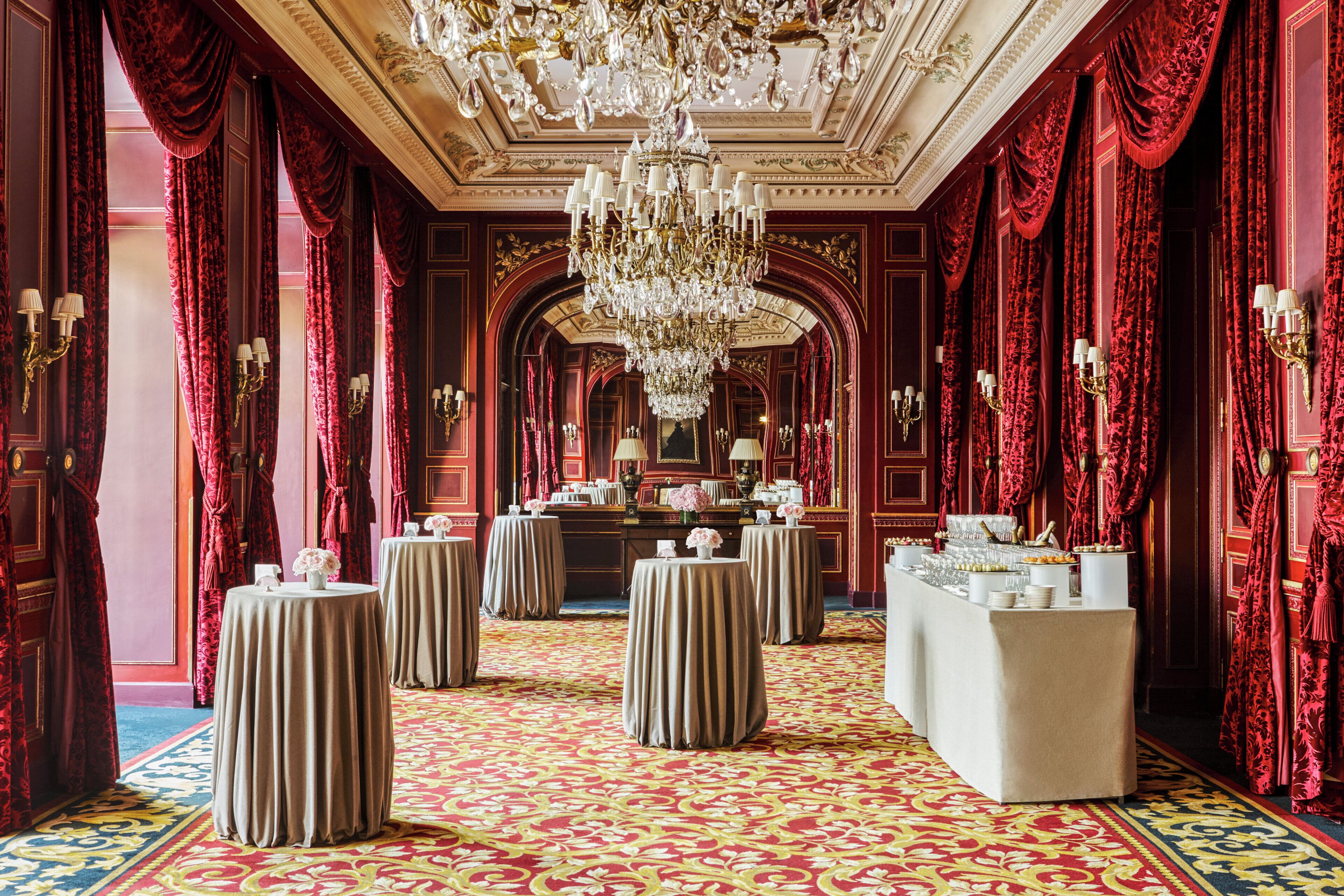 Eine prachtvolle Hotelhalle mit rotem Teppich, aufwendigen Kronleuchtern und stilvoller Ausstattung.