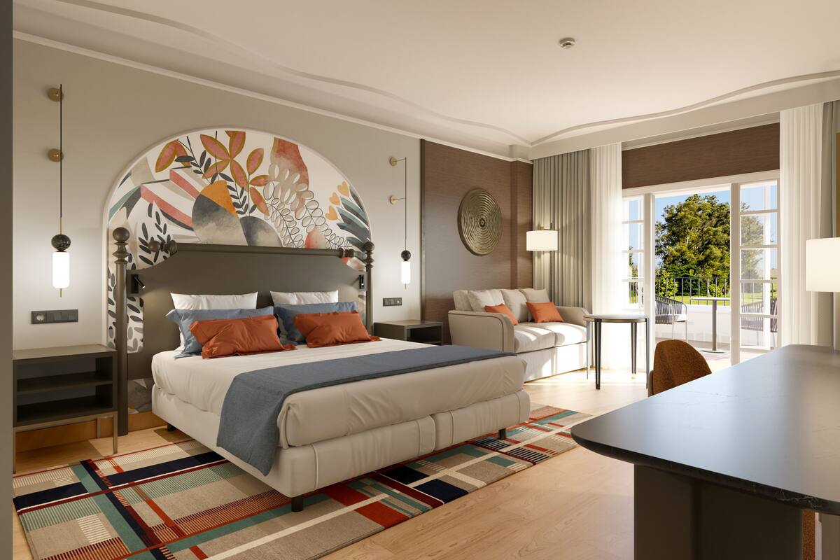 Une chambre d’hôtel moderne dotée d’un grand lit, d’un canapé, d’une table à manger et offrant une vue sur l’extérieur.