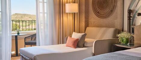 A hotel room with two beds, a balcony with a table and chair, a lamp, and a decorative wall piece.