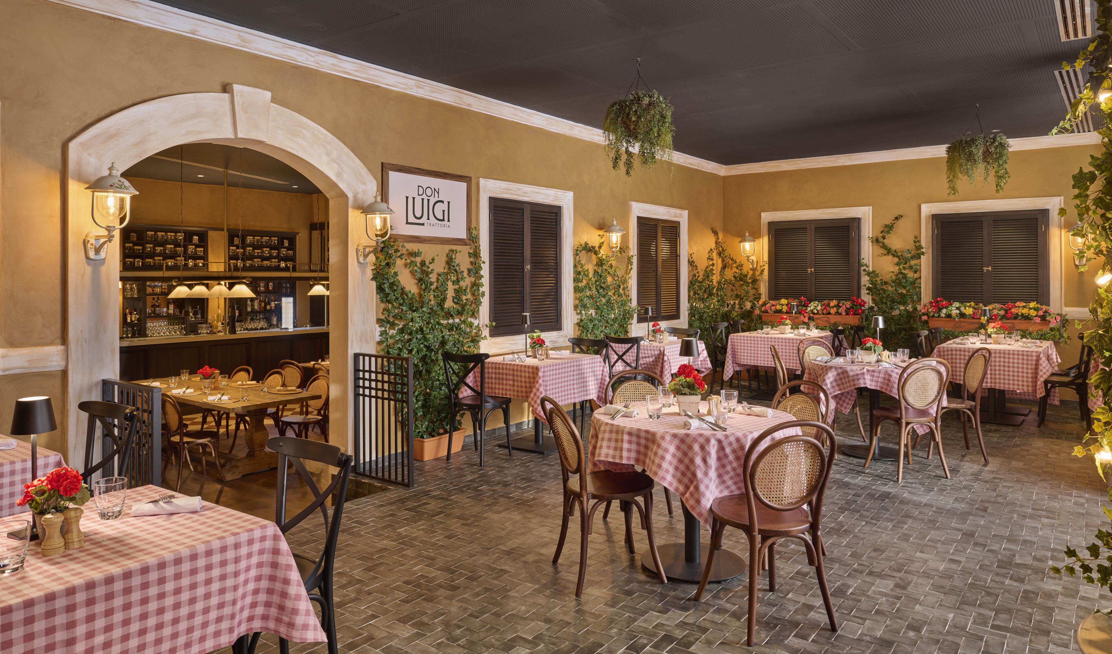 Un espace de restauration intérieur avec des nappes à carreaux, des chaises en bois et un bar avec des étagères remplies de bouteilles.