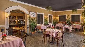 Un espace de restauration intérieur avec des nappes à carreaux, des chaises en bois et un bar avec des étagères remplies de bouteilles.