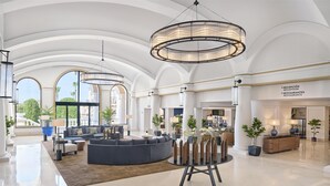 Eine geräumige Lobby mit großzügiger Sitzecke, einer Rezeption und Blick ins Freie.