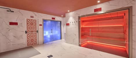 A spa area with a blue door, a red-lit sauna, and a marble wall.
