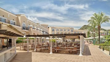 Un complejo turístico con zonas de comedor al aire libre, piscina y un restaurante llamado Soly Sombra.