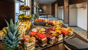 A buffet with various desserts and fruits.