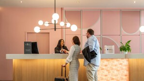 A reception desk with a modern design, a reception area, and a wooden floor. - Mercure Salzburg City (Salzburg)