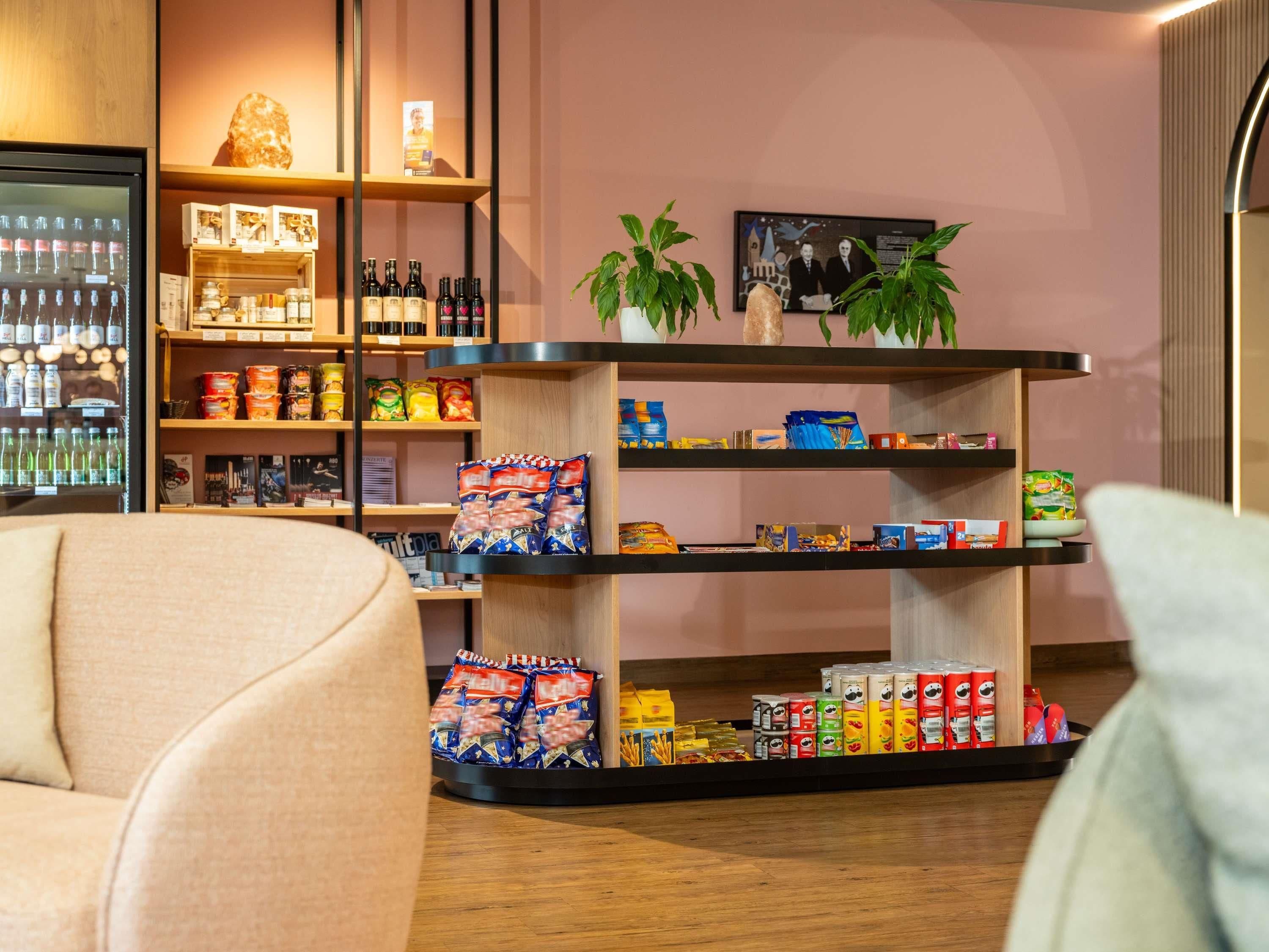 Un espacio comercial moderno con estantes llenos de bocadillos, bebidas y productos envasados.