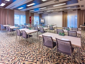 A conference room with tables, chairs, a projector screen, and a Coca-Cola refrigerator. - Mercure Salzburg City (Salzburg)