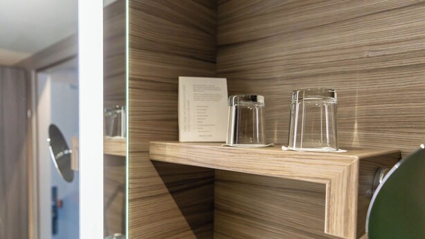 A wooden shelf with two clear glass jars and a menu card. - Mercure Salzburg City (Salzburg)