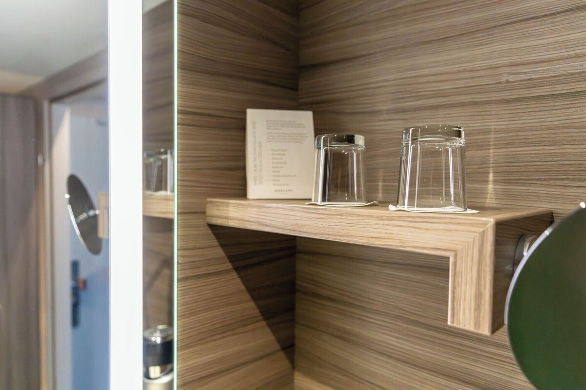 A wooden shelf with two clear glass jars and a menu card.
