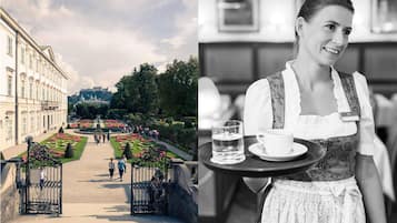 A historical building with a garden pathway and a person serving a tray with a glass of water and a cup.