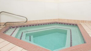 Ein rechteckiger Pool mit einer Fliesenbordur und einer Metallhandstange.