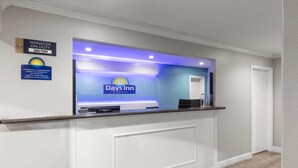 A reception desk with a sign for Days Inn by Wyndham, a manager on duty sign, and a property management sign. - Days Inn by Wyndham Temple (Temple)