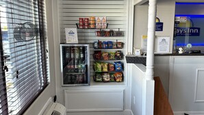 A hotel room with a kitchenette, a minibar, and a window with blinds. - Days Inn by Wyndham Temple (Temple)