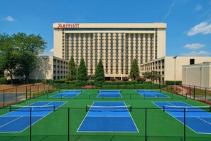 Un hôtel Marriott doté de plusieurs courts de tennis situés à l’avant.