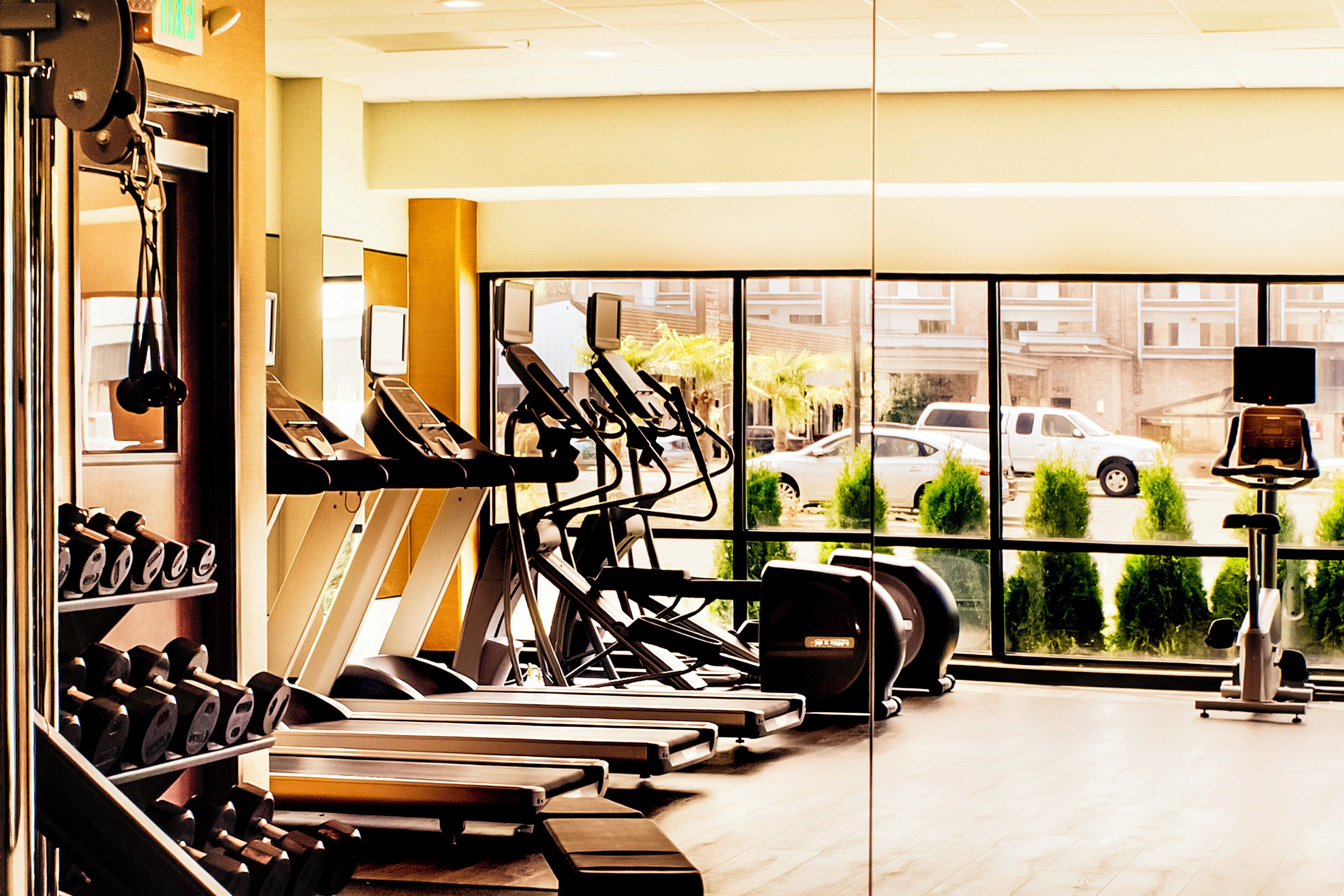 Une salle de sport équipée de tapis de course, d’haltères et d’autres appareils d’exercice.