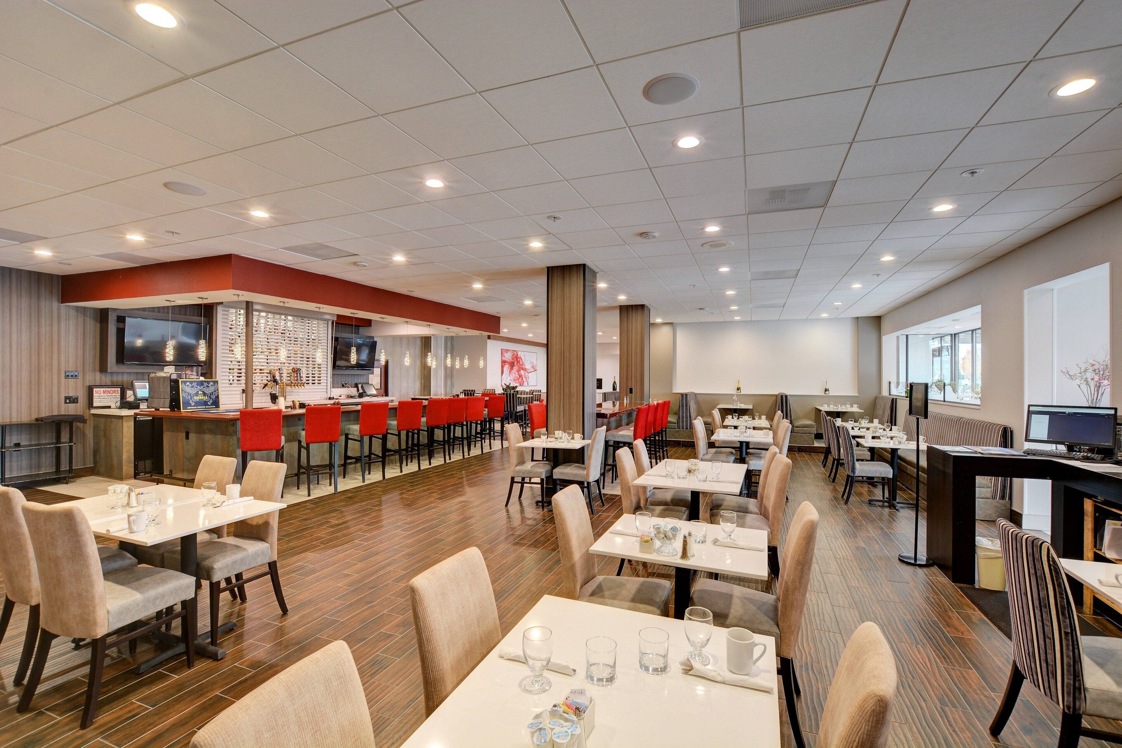 A spacious restaurant with multiple dining areas, a bar, and a seating arrangement that includes both booths and tables.