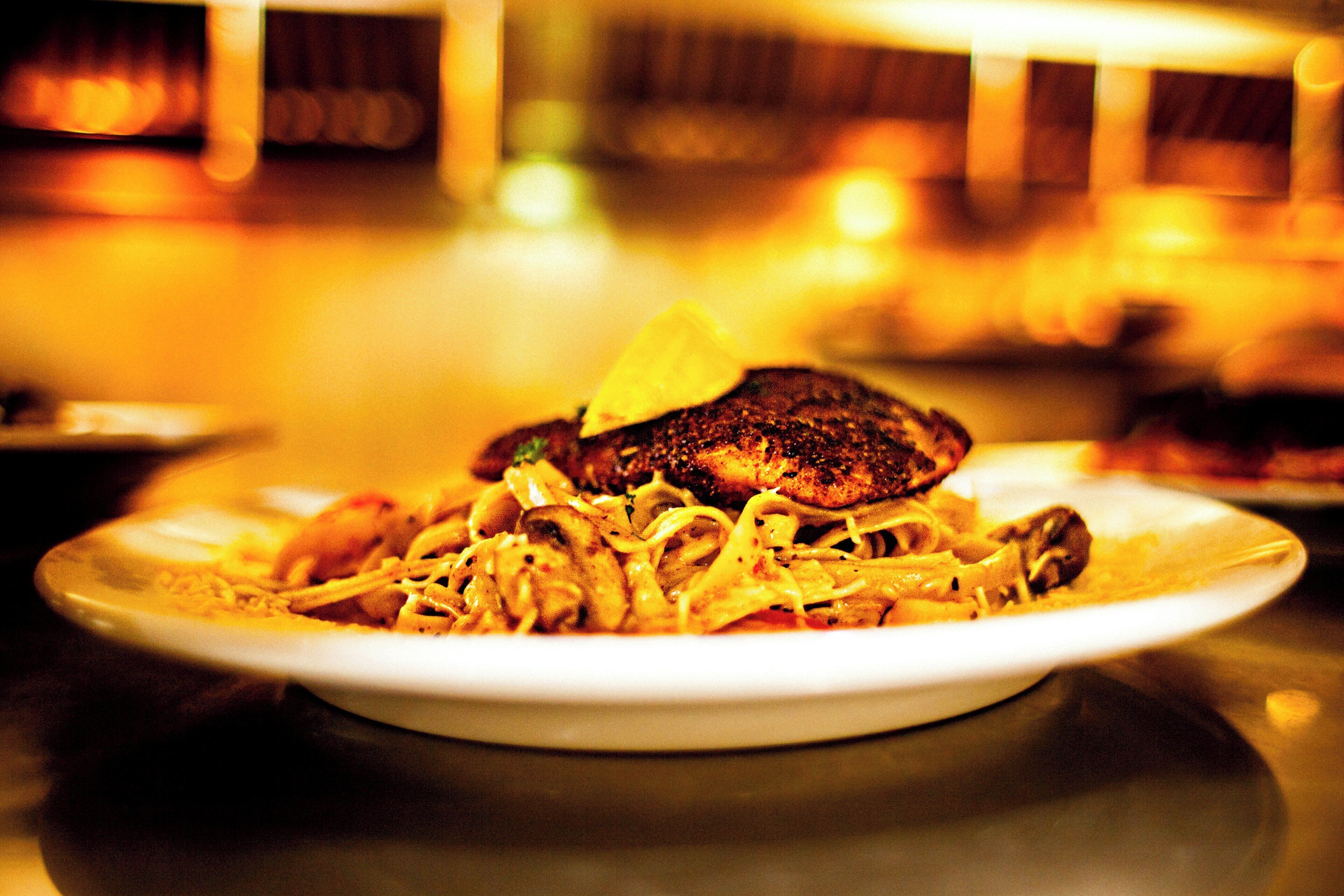 A plate of food with a piece of meat and noodles.