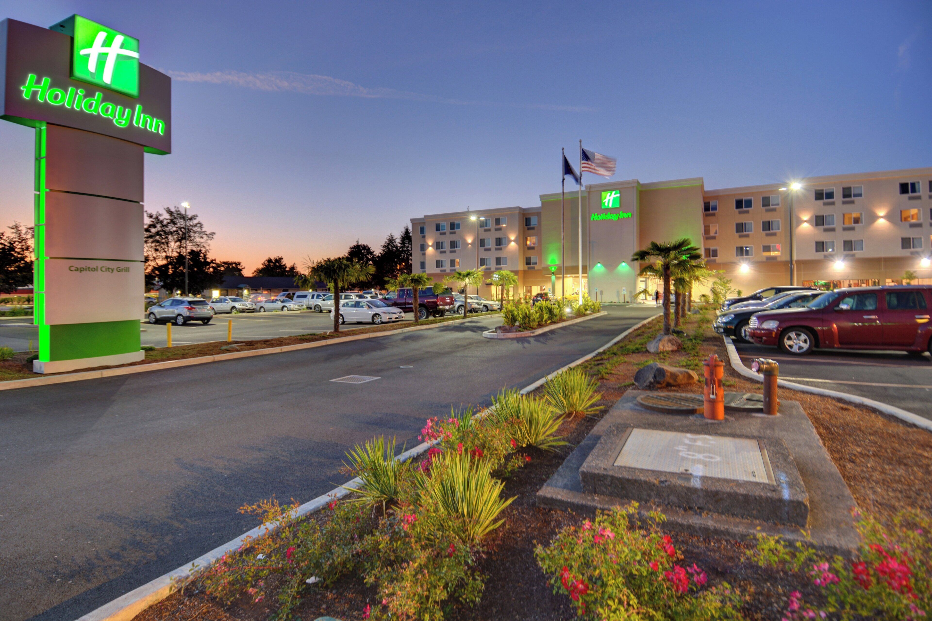 Un hôtel Holiday Inn doté d’un parking, d’un restaurant appelé Capitol City Grill et d’une entrée bien éclairée.