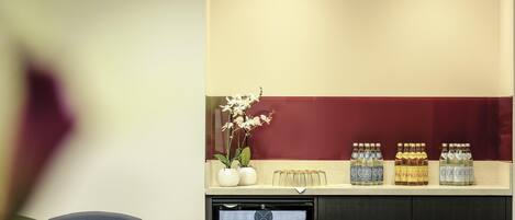 Una sala de estar con sillas y un refrigerador lleno de bebidas.