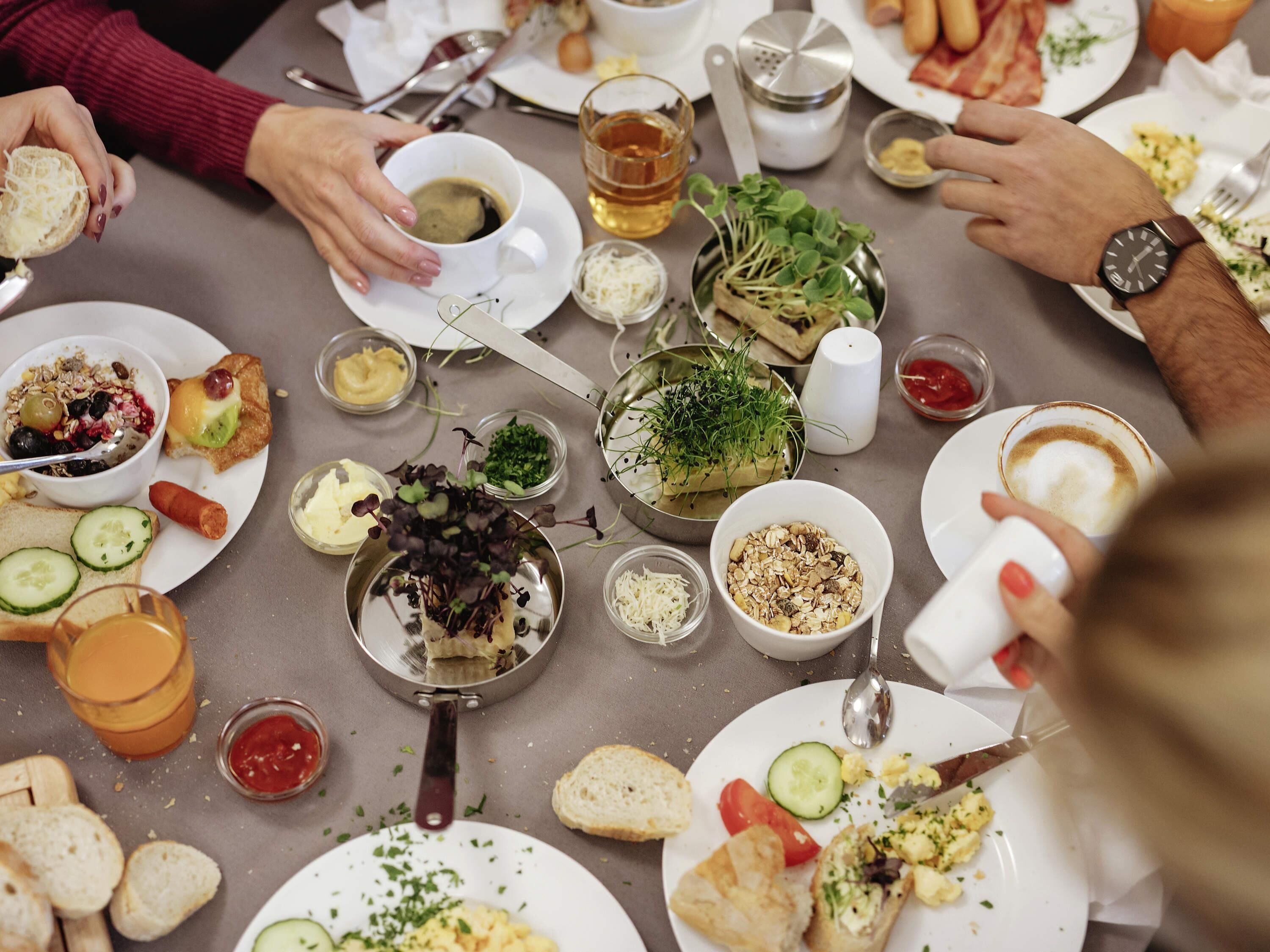 A dining table with various dishes, utensils, and a salt shaker.