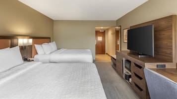 Habitació d'hotel amb dos llits, televisió i escriptori de fusta.
