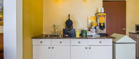 Una cocina con cafetera y máquina para hacer gofres.
