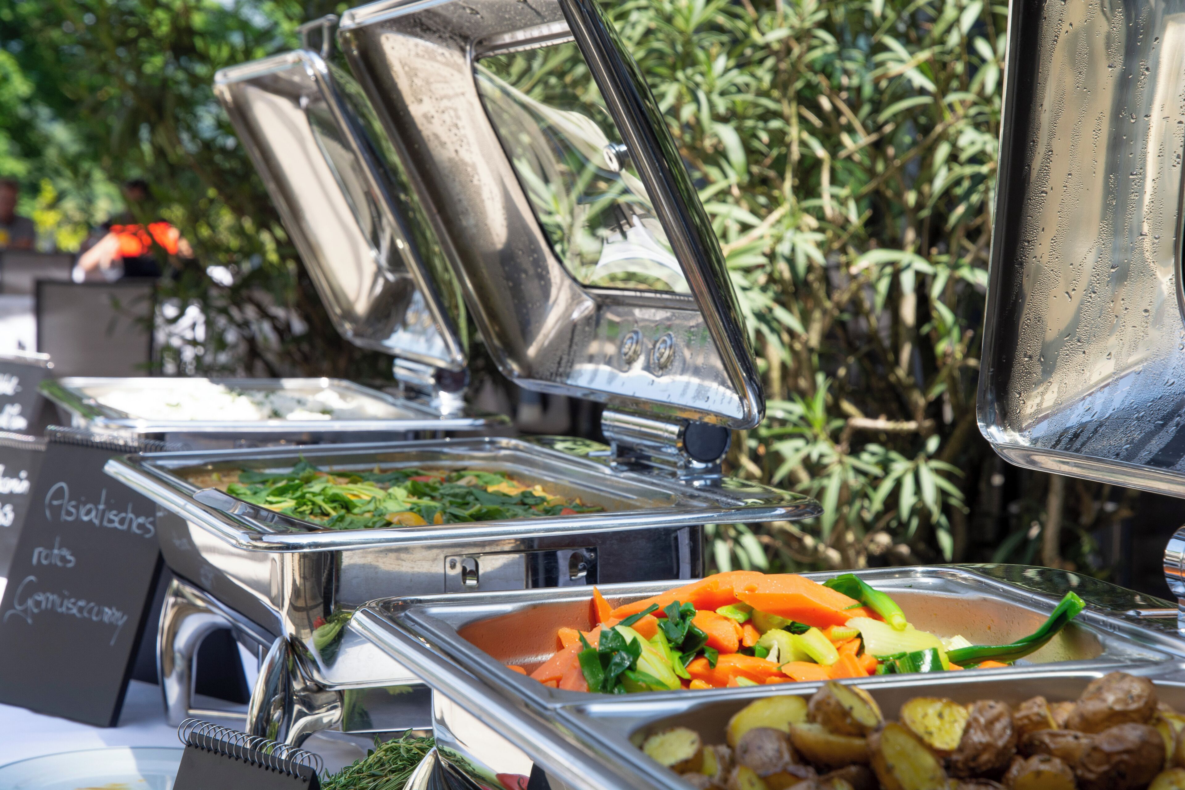 A buffet with various food items including vegetables and potatoes.