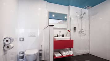 A modern bathroom with a glass shower enclosure, a white toilet, a red vanity, and a white sink.