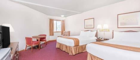 A hotel room with two beds, a desk with a chair, a television, and a window with curtains.