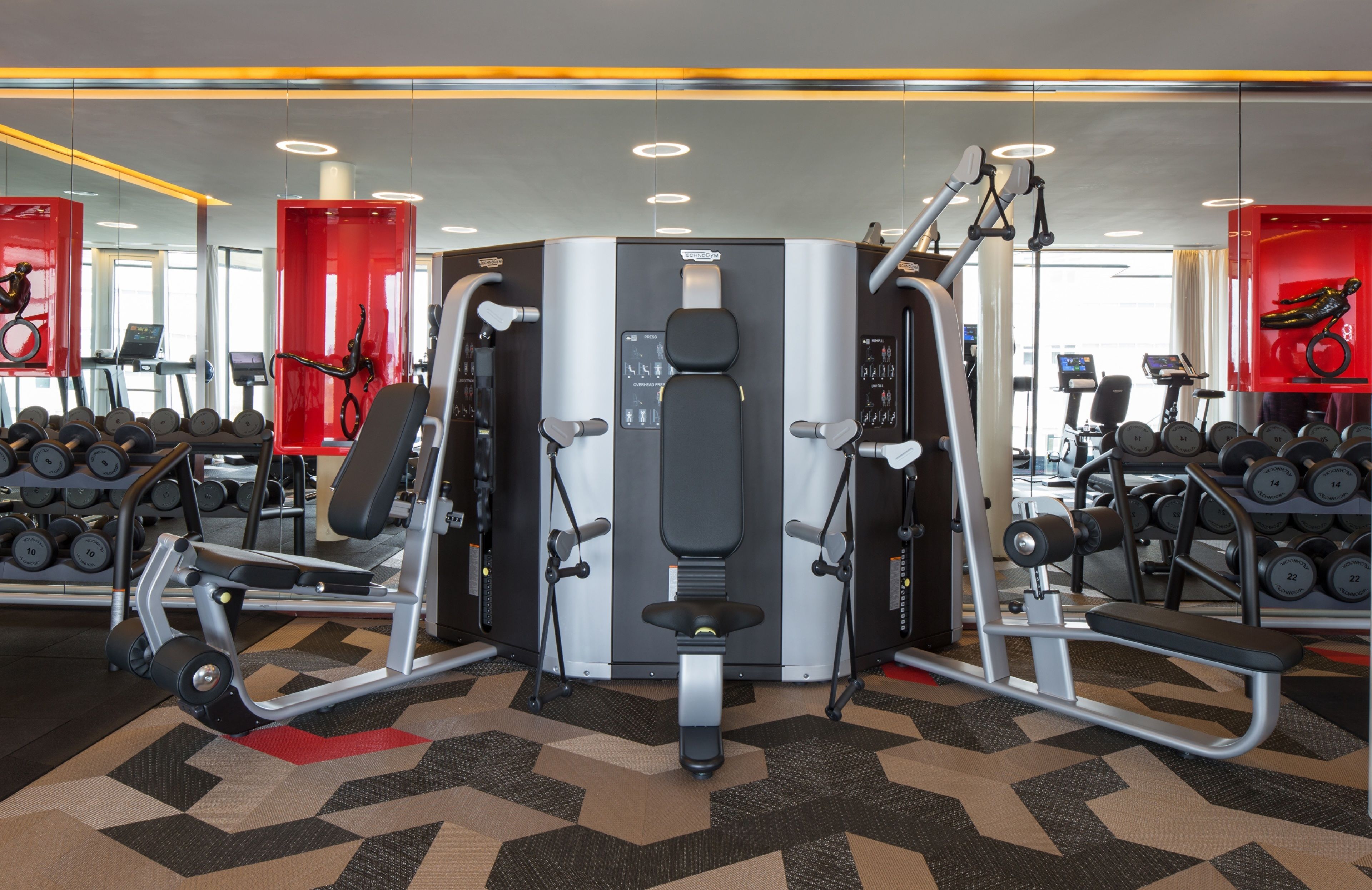 A gym with various exercise equipment, including weight machines and dumbbells.