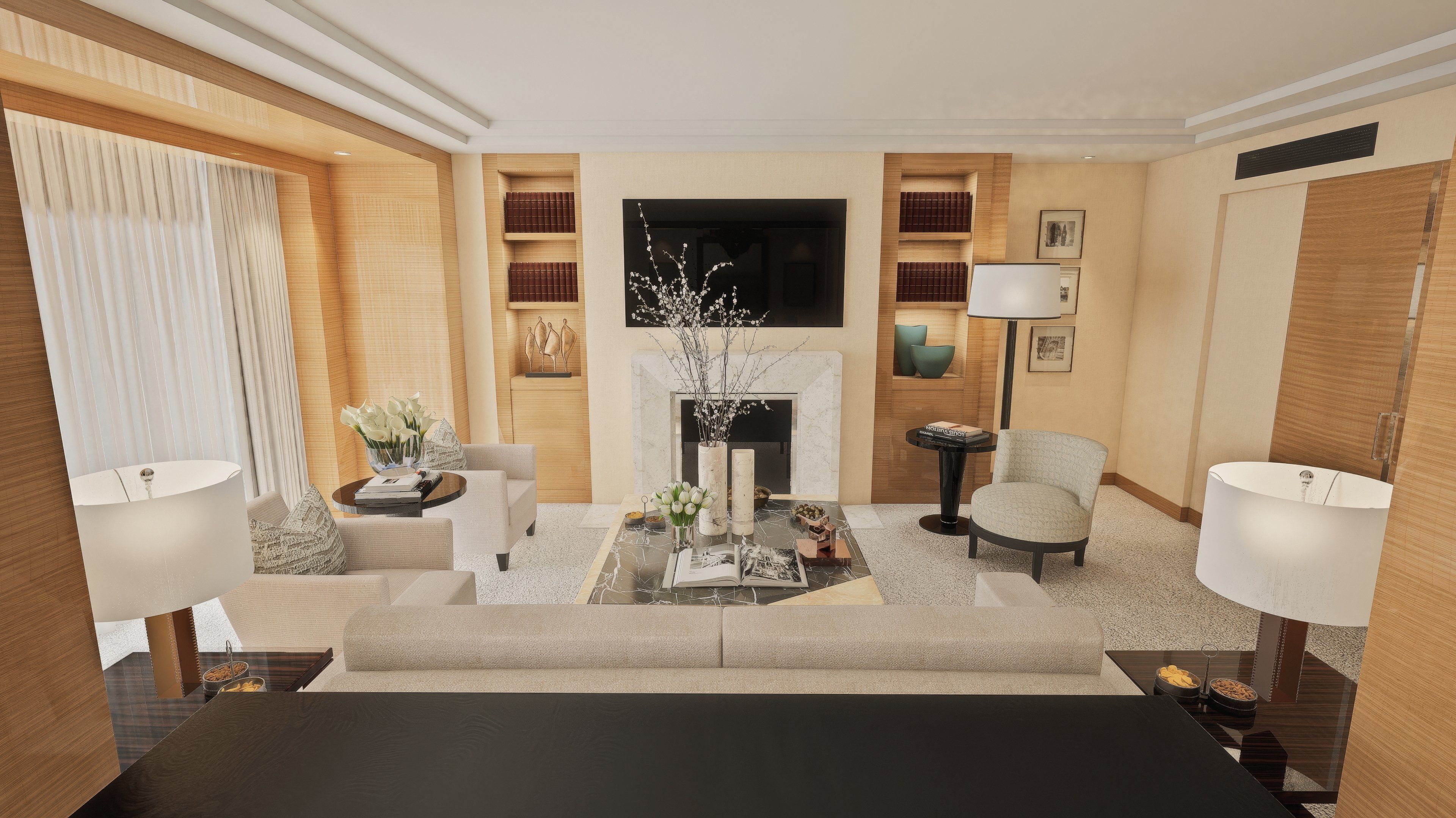 A modern living room with a sofa, armchairs, a coffee table, and a fireplace. There are bookshelves and a flat-screen TV mounted on the wall.