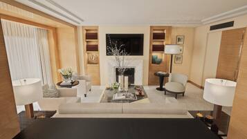 A modern living room with a sofa, armchairs, a coffee table, and a fireplace. There are bookshelves and a flat-screen TV mounted on the wall.