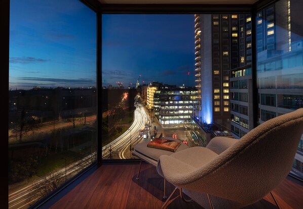 Enjoy unobstructed city views from the plush armchair near the large window.