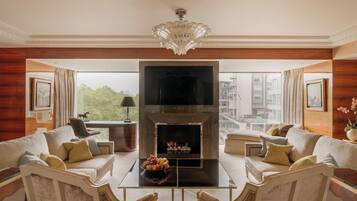 A spacious living room with a fireplace, comfortable seating, and a large window offering a city view.