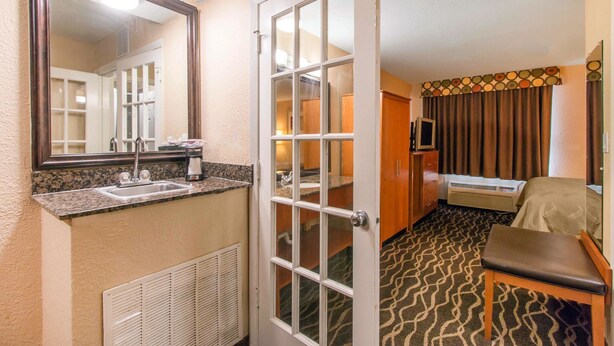 Une salle de bain d’hôtel avec un lavabo, un miroir et une douche.