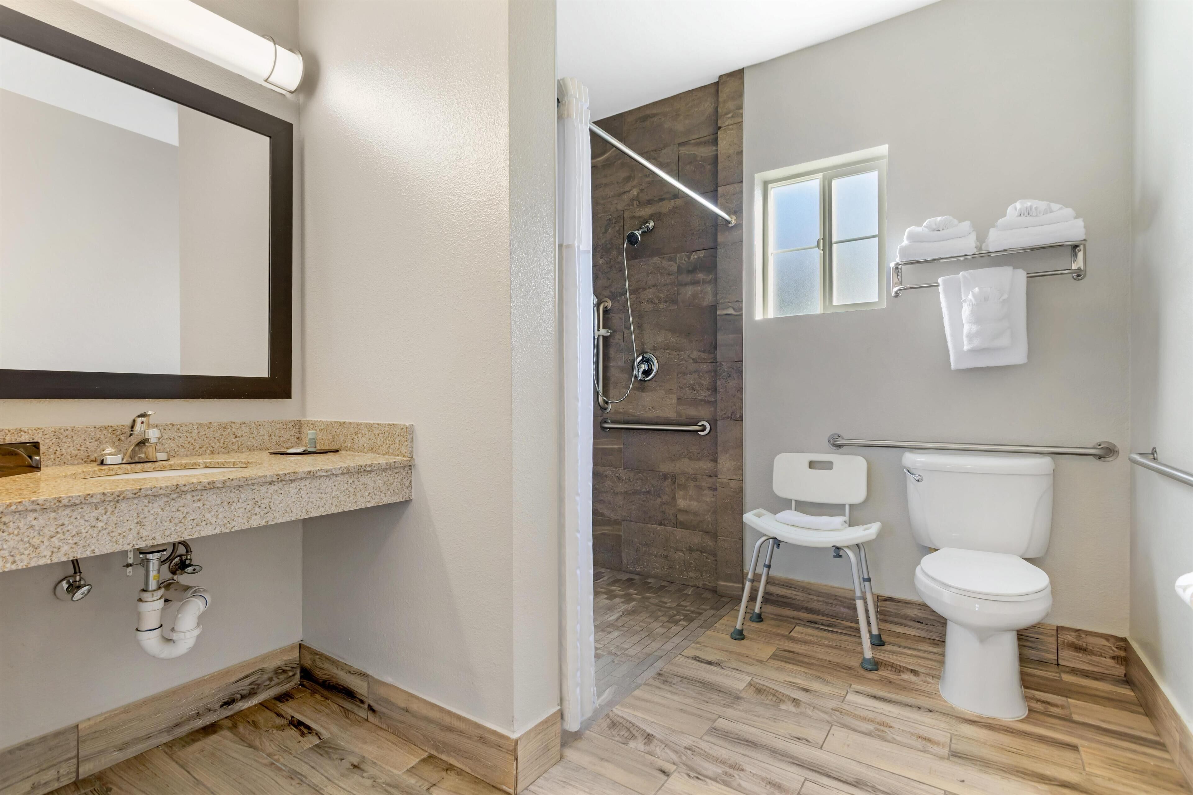 A modern bathroom with a shower, toilet, and sink.