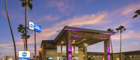A Best Western hotel with a lobby entrance, stone pillars, and a clear sky.