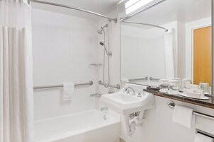 Un bagno moderno con vasca, lavandino e doccia.