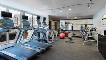 Un gimnasio con cintas de correr, pelotas de ejercicio y máquinas de pesas.