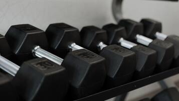 A close-up of a set of black dumbbells with visible weight markings.